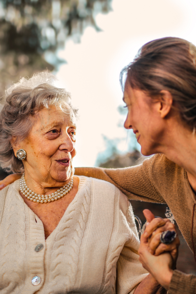 In-home caregiver helping an older adult move safely through a well-lit, hazard-free home in Newport Beach