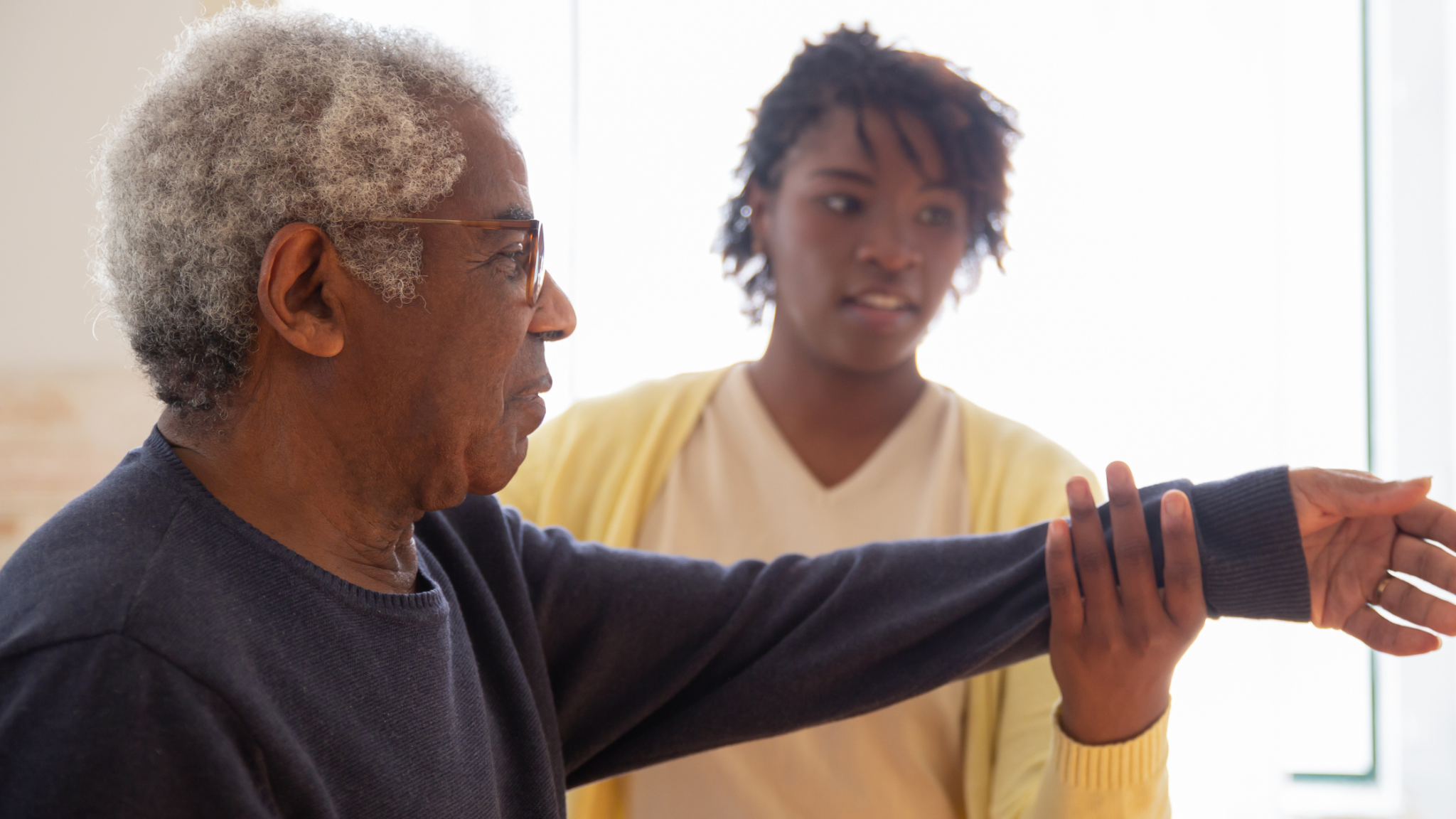 In-home caregiver helping an older adult stay steady and safe while walking at home in Newport Beach